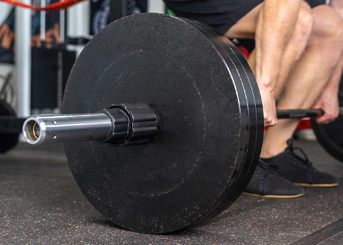man deadlifting with husker power lock in gym