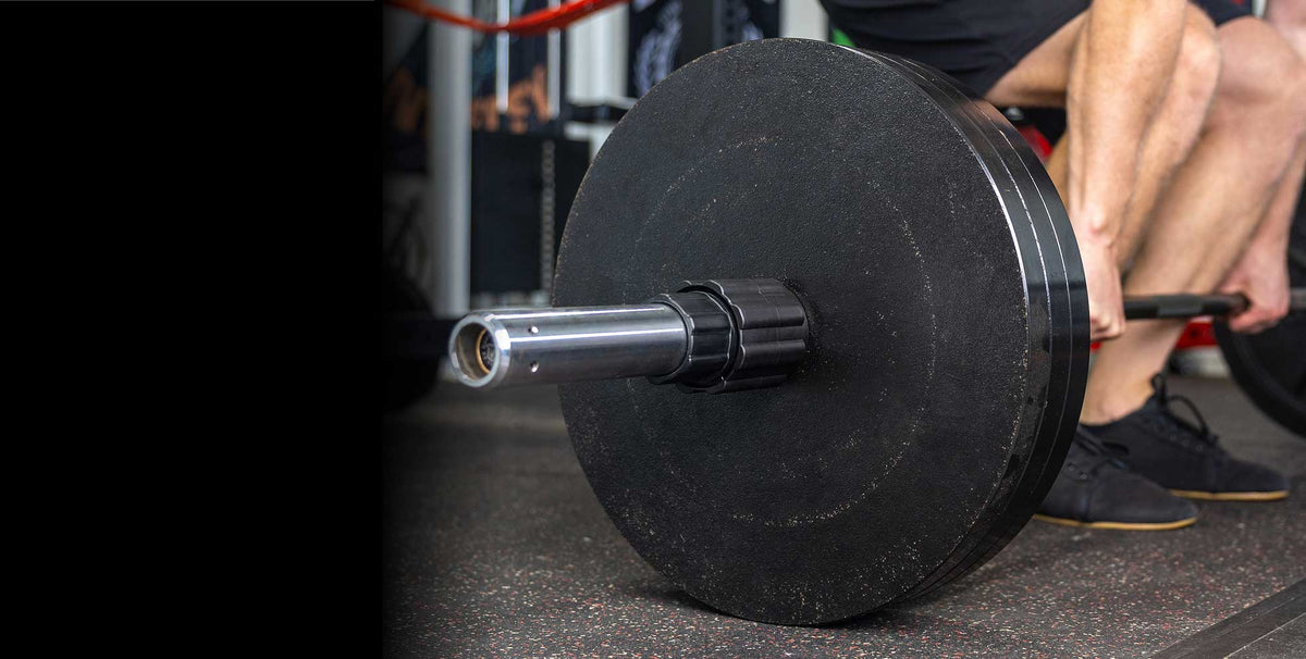 man deadlifting with husker power lock on barbell
